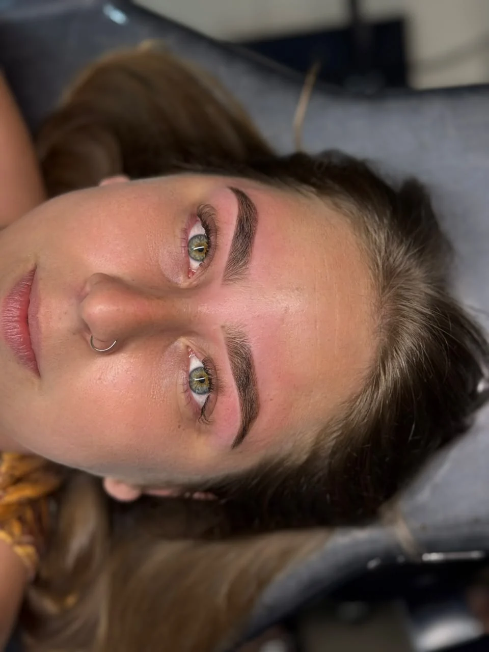 Cliente com piercing no nariz e sobrancelhas definidas após design com henna.